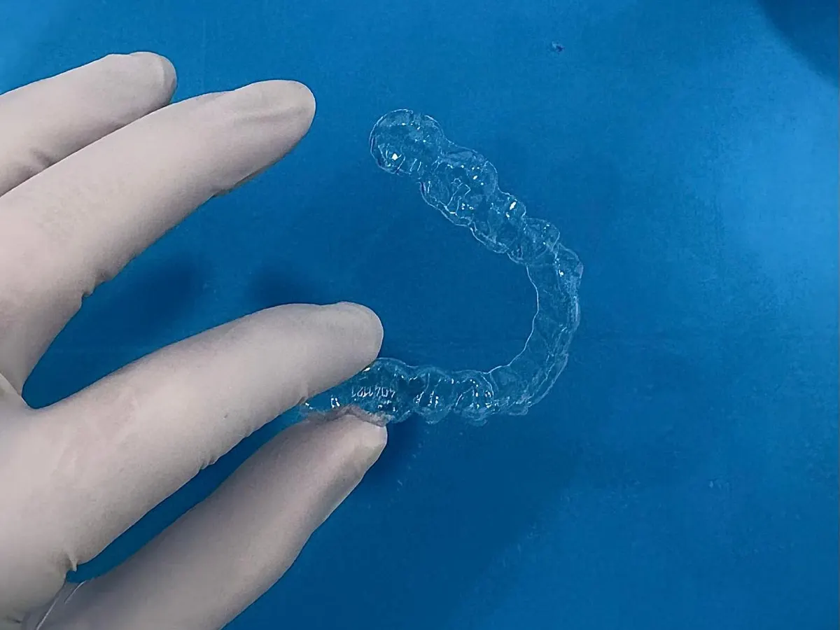 Alineador transparente sujeto con la mano enguantada